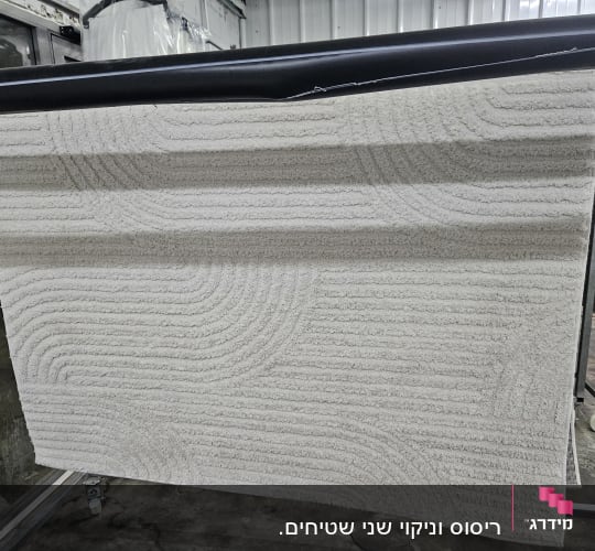 שטיח לבן תלוי לייבוש לאחר ניקוי